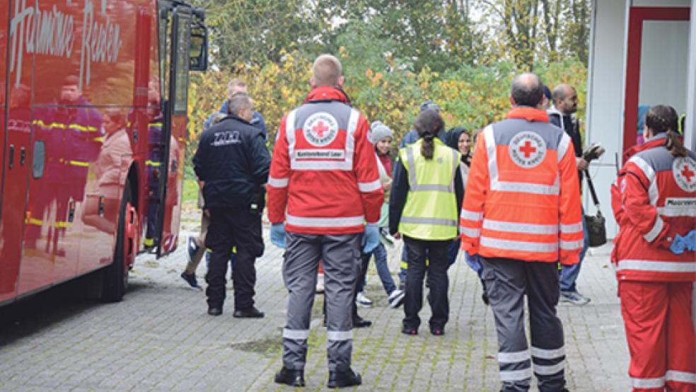 Beschützt und abgeschirmt werden die Flüchtlinge vom Bus in die Mensa der Oberschule geleitet. Hier werden sie über den weiteren Ablauf informiert und erhalten ein Lunchpaket. © Foto: Hanken