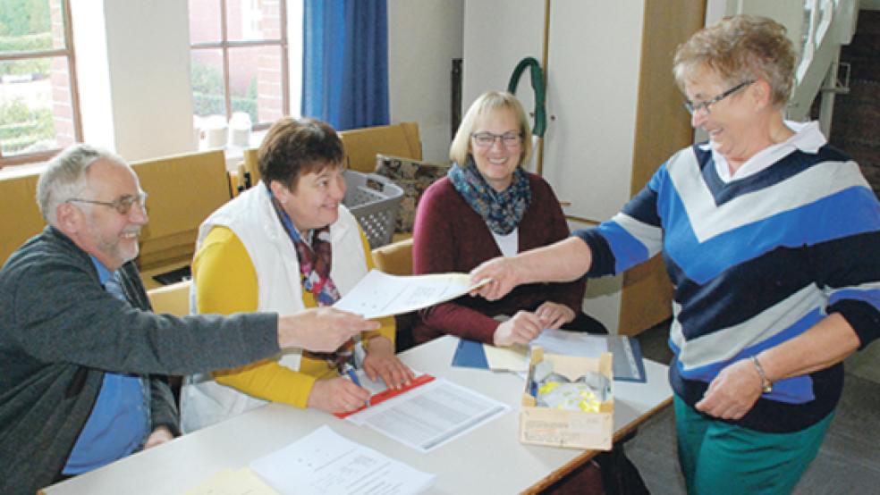Gemeindewahl in Ditzumerverlaat: Im Wahlbüro nehmen (von links) Diddo Geerdes, Edith Wirtjes und Johanne Wilken (Kirchenratsvorsitzende) den Stimmzettel von Miene Derr entgegen. © Foto: Kuper