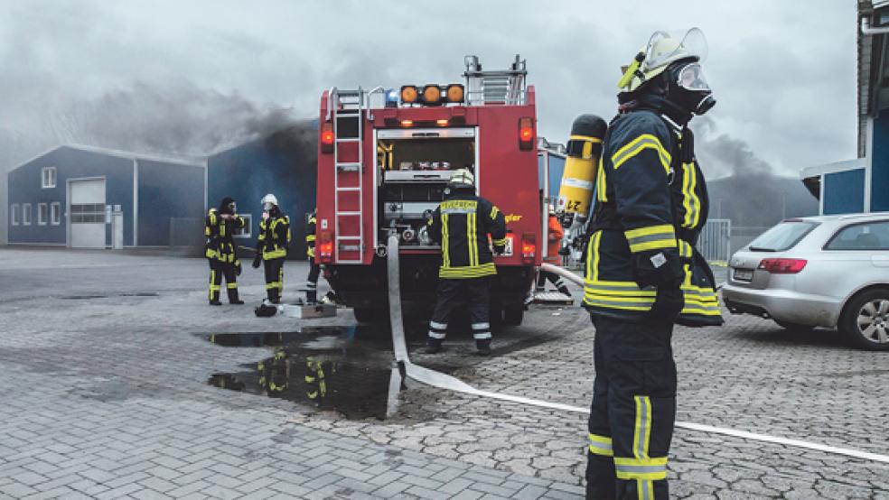 Dunkle Rauchschwaden zogen gestern Nachmittag aus einer Produktionshalle der Dannen Planenservice GmbH im Gewerbegebiet an der Industriestraße in Weener. In der Halle stand auch ein Gabelstapler. Die Brandbekämpfer trugen schweren Atemschutz. © Fotos: Klemmer