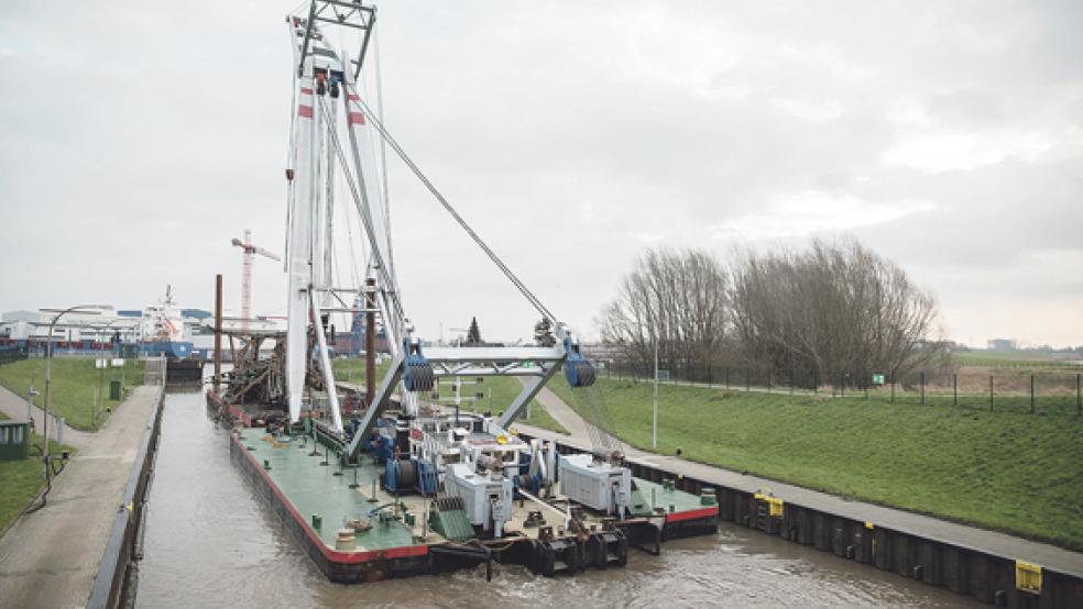 Mit einem Haufen Stahlschrott auf einem Ponton und der Unterstützung eines Schleppers fuhr der Schwimmkran »Triton« gestern Vormittag durch die Leeraner Seeschleuse. © Foto: Klemmer