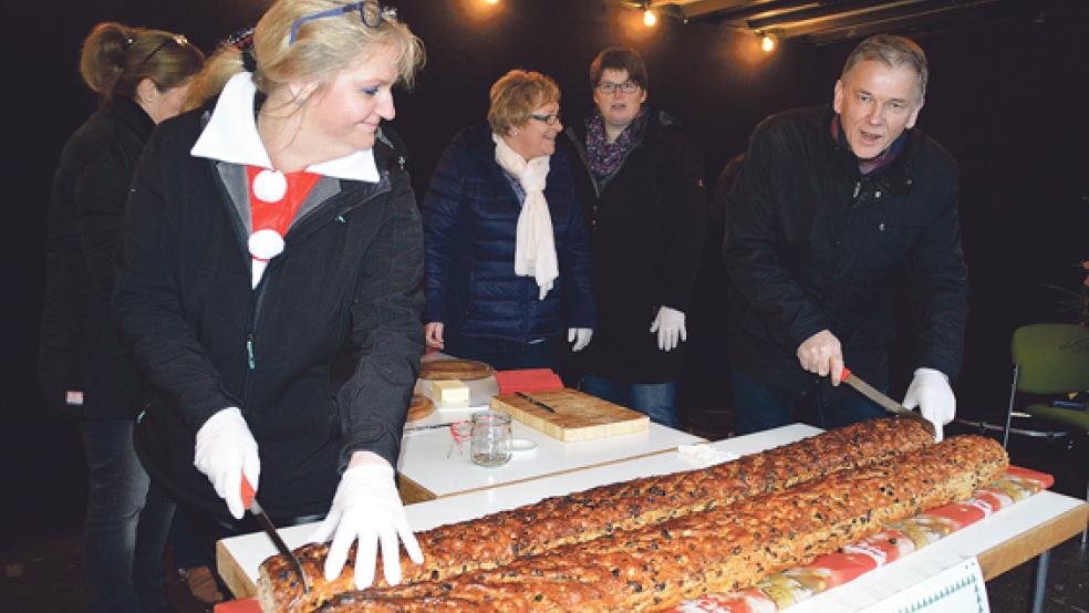 Alles hat ein Ende - nur der Stuten hat zwei! Gewerbevereinsvorsitzende Birgit Lübbermann-Gabriel und Bürgermeister Gerald Sap beim offiziellen Anschnitt des Riesenkrintstuut zu Gunsten der Flüchtlingshilfe. © Foto: Himstedt 