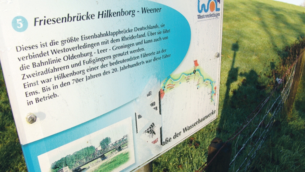 Als größte Eisenbahnklappbrücke Deutschlands wird die Friesenbrücke zwischen Hilkenborg und Weener auf diesem Schild der Gemeinde Westoverledingen gepriesen. © Foto: Boelmann