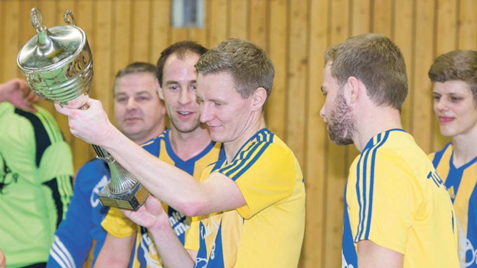 Den Pokal für den Sieger bestaunten im vergangenen Jahr die Fußballer des TuS Weener, hier Dennis Boelen, Markus Janssen und Kevin Kessens (v. l.). © Foto: Mentrup