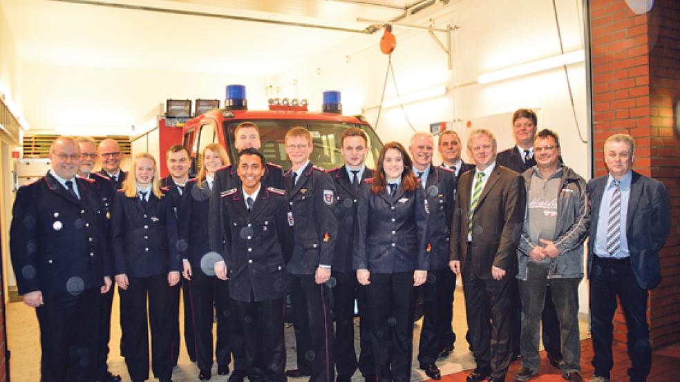 Die beiden neuen Chefs, Ortsbrandmeister Alwin Meints (Dritter von rechts) und Stellvertreter Klaas-Enno Haken (Achter von links), und ihr Vorgänger Frank Thomas Obst (Fünfter von rechts) mit ihren Gästen, den Beförderten, den Ernannten und weiteren neuen Würdenträgern im Ortskommando.  © Foto: Himstedt