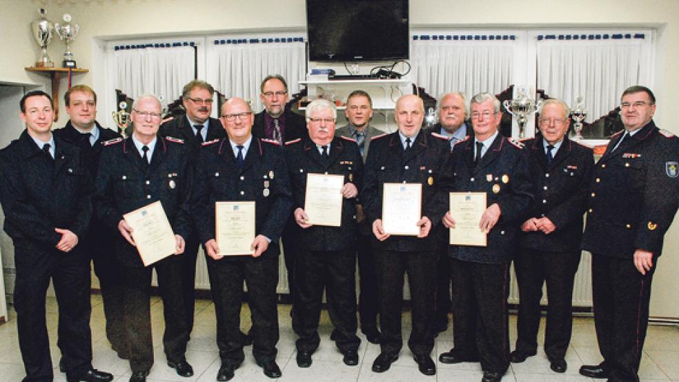 Fünf Alterskameraden der Ortsfeuerwehr Dollart wurden für ihre langjährige Mitgliedschaft geehrt: (von links, mit Urkunde) Heinz Reck (25 Jahre), Hilko Buß (40), Kurt Voß und Klaus-Dieter Buss (beide 50) sowie Monne de Vries (60). Glückwünsche, Urkunden, Anstecknadeln, Bandschnallen, Präsente und Geschenkkörbe gab es von (2. Reihe, von links) Ortsbrandmeister Thomas Kempen und seinem Stellvertreter André Buss, der zum Löschmeister befördert wurde, Gemeindebrandmeister Ingfried Battermann, Harm Watermülder (Fachbereichsleiter Gemeinde Bunde), Bürgermeister Gerald Sap, Johannes Willms (Feuerwehrausschussvorsitzender), Jan Brandt (Ehrenortsbrandmeister) und Kreisbrandmeister Theodor de Freese.  © Foto: Kuper