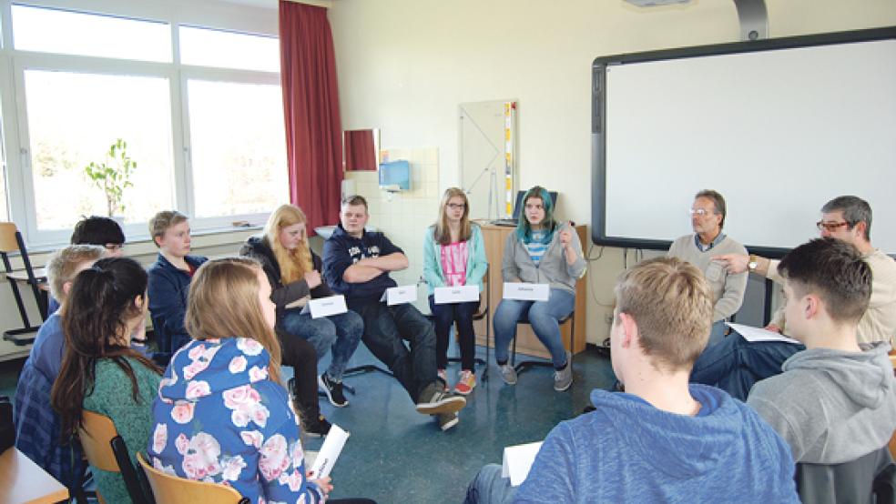 Ein »Stuhlkreis« über Kommunalpolitik: Die Politiker-Patenkinder der Oberschule Weener zusammen mit den beiden Paten Lutz Drewniok (hinten, Zweiter von rechts) und Axel Bareiß (rechts neben ihm). © Foto: Hoegen