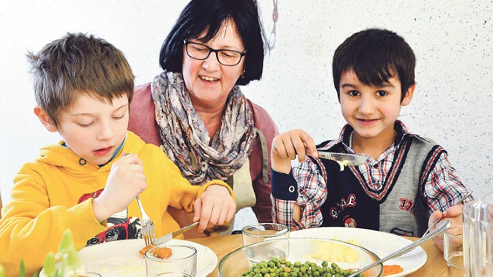 Luise de Vries ist die neue Küchenchefin in der Kindertagesstätte »Jona« in Weener. Auch Florjan (links) und Akbar mögen ihre ostfriesische Hausmannskost. © Fotos: Boelmann