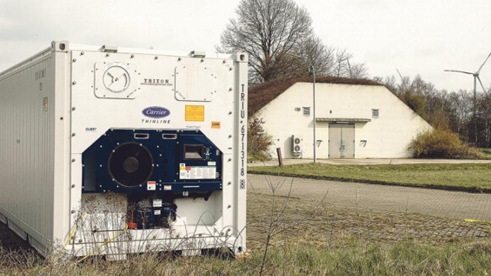 40 Kühlcontainer stehen auf dem Gelände des Materiallagers in Weener bereit zur Einlagerung von leicht brennbaren Lithium-Batterien. Später sollen sie in die sieben erdummantelten Bunker (im Hintergrund) umgelagert werden. © Foto: Szyska