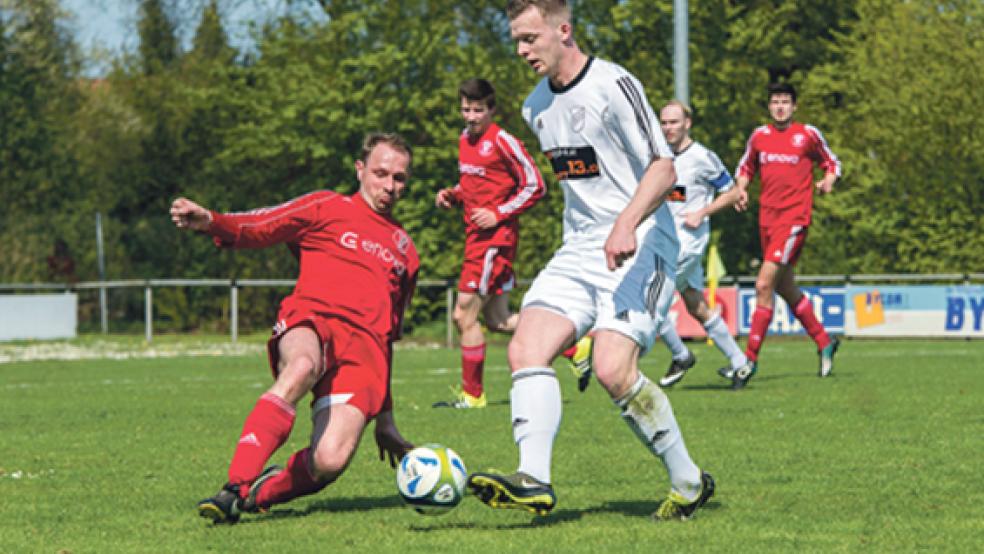 Zur Grätsche setzt Bundes Johann Lübbers (links) in dieser Szene gegen Nordhorns Joshua Sausmikat an. Mit dem Doppeltorschützen hatten die Rheiderländer vor allem in der ersten Hälfte Probleme.  © Foto: Mentrup