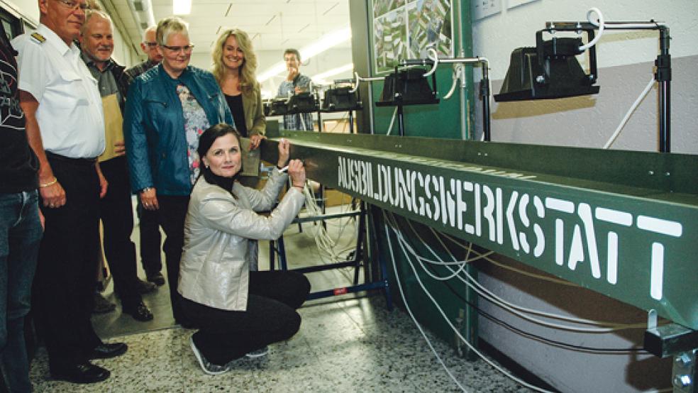 Mit ihrer Unterschrift auf die zehn Meter lange Solar-Teststrecke einer ABW-Projektgruppe unterstützte die CDU-Bundestagsabgeordnete Gitta Connemann (hockend) gestern die Teilnahme der Auszubildenden an der Sollar-Rallye mit selbstentwickelten Fahrzeugen, die am 11. Juni auf dem Campus der Hochschule Emden stattfindet. Auch (stehend von links) der Leiter des Bundeswehr-Depots Nord, Lothar Koch, ABW-Leiter Uwe Neessen, die CDU-Ratsfrau Hildegard Hinderks und die Gleichstellungsbeauftragte des Bundeswehr-Depots Nord, Silvia Stein aus Holthusen, wünschten gutes Gelingen. © Foto: Szyska