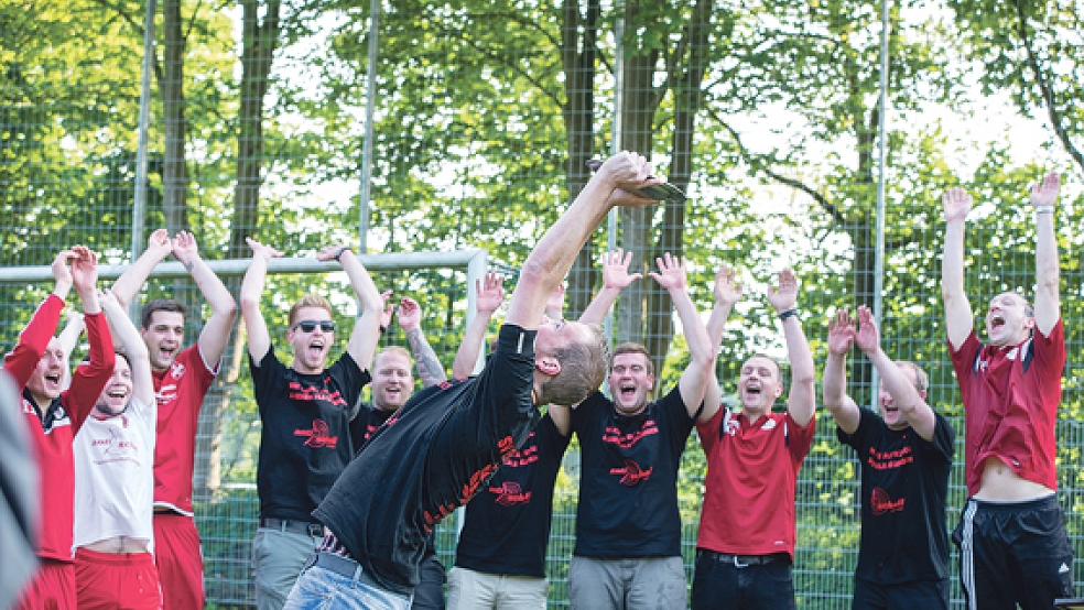 Der SV Ems hat die Schale: Matthias Hilbrands reckt die Trophäe in die Höhe, seine Mannschaftskollegen feiern mit ihm. © Fotos: Mentrup