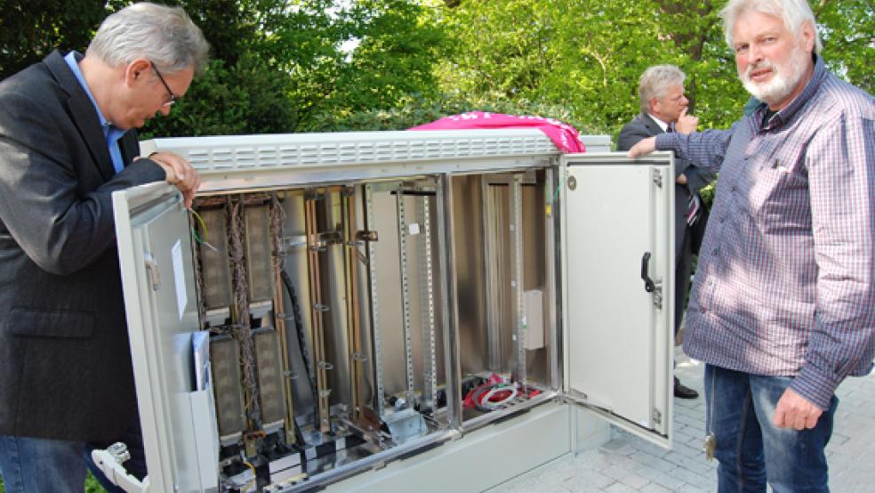 Hans Pruin (rechts), Mitarbeiter der Telekom, gewährte der RZ an der Norderstraße in Weener einen Blick in das Innere eines der neuen Verteilerkästen. © Foto: Hoegen