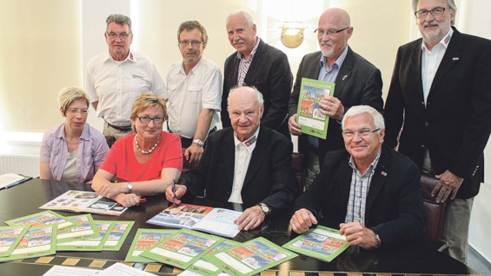 Verkehrswachten und Brandkasse mit der Broschüre: (von links, stehend) Diedrich Draeger (Emden), Heinz Kurrelfink (Rhauderfehn), Klaus Wilbers (Wittmund), Hajo Heershemius (Norden) und Hans-Jürgen Dieken (Aurich) sowie (von links, sitzend), Ute Kaiser (Rhauderfehn), Signe Foetzki (Brandkasse), Karl-Heinz Jesionek (Ostfriesland) und Georg Reichelt (Leer). © Foto: Jürgens