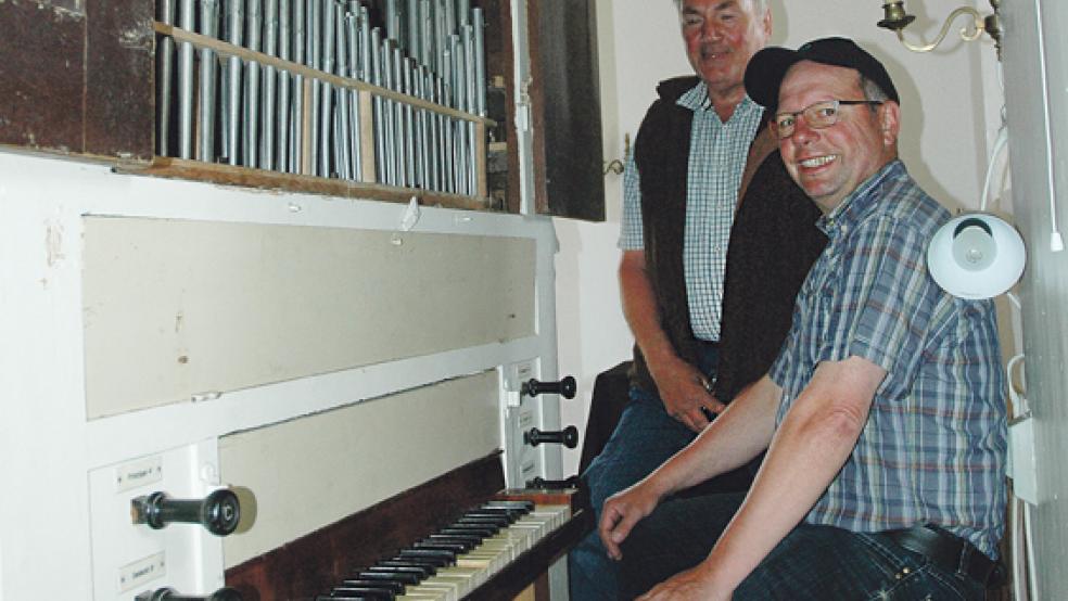 Der Kirchenratsvorsitzende Wübbo van Lessen (links) und sein Stellvertreter Peter Rösing an der 1853 in Hamburg gebauten Orgel. Das Instrument kam 1939 nach Critzum. © 
