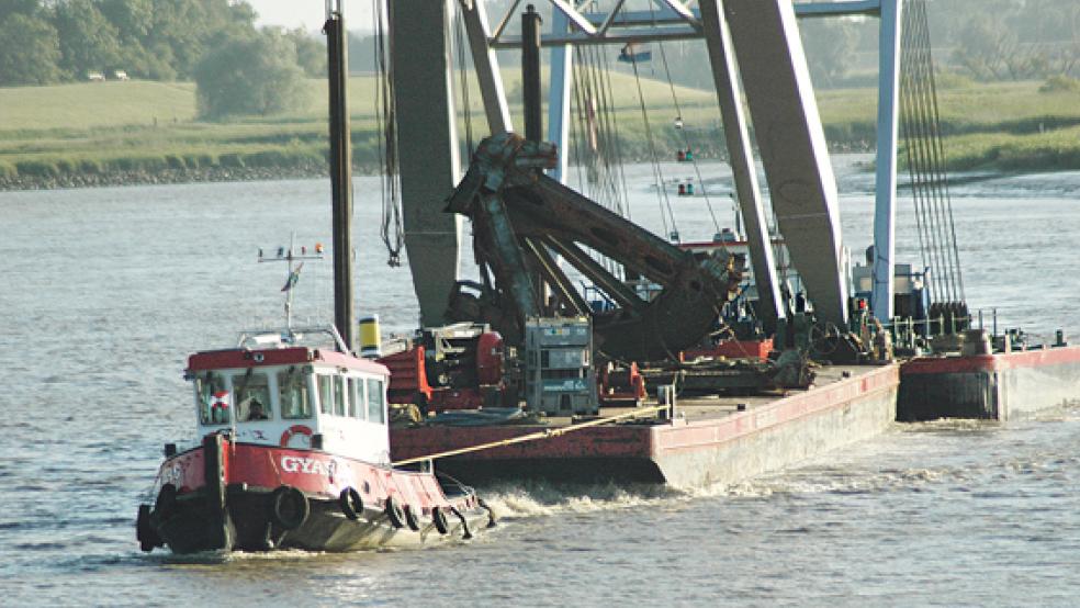 Leerort, Donnerstagabend, 20 Uhr: Der Schlepper »Gyas« zieht das Pontonschiff und den Schwimmkran »Triton« über die Leda und bringt das abgetrennte Drehkreuz der Friesenbrücke zur Recycling-Firma »Interseroh Heeren« nach Leer. Das Kontergewicht blieb indes auf der beschädigten Eisenbahnbrücke in Weener. © Foto: Szyska