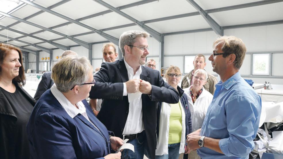 CDU-Landratskandidat Dirk Lüerßen (Mitte) testet die Reißfestigkeit einer Plane von »Dannen-Planenservice« in Weener. Geschäftsführer Siegfried Dannen (rechts) stellte die Arbeit seines Betriebes gestern Nachmittag bei einem Besuch der Christdemokraten vor.  © Foto: Boelmann