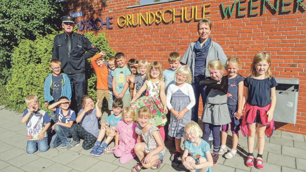 Verkehrsunterricht auf der Straße: Polizeioberkommissar Arno Oltrop mit den Kindern der Klasse 1b der Grundschule Weener und ihrer Leherin Almut Janssen. © Foto: Muising