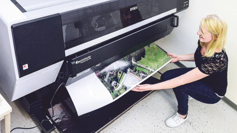 Der Ausdruck eines großen Posters dauert mit dem elf Farben-Großformatdrucker nur wenige Minuten. Mediengestalterin Sandra Mühlenbrock begutachtet den Ausdruck eines Kundenauftrages. © Foto: Klemmer