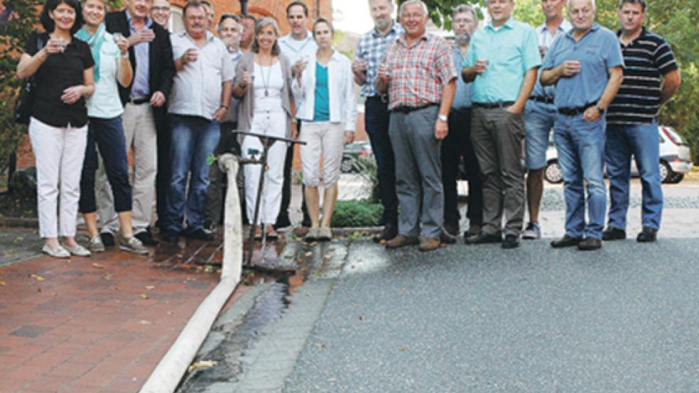 »Zum Wohle«: Die Mitglieder des Verbandsausschusses und Vertreter verschiedener Behörden kosteten gestern an verschiedenen Standorten im Rheiderland einen Schluck Trinkwasser direkt aus dem Hydranten - auf unserem Bild in der Marktstraße in Weener. © Foto: Szyska
