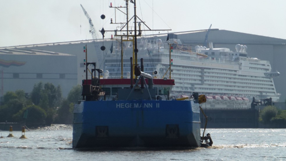 Das Baggerschiff »Hegemann II« auf der Ems - im Hintergrund das Kreuzfahrtschiff »Genting Dream«. © Foto: Bürgerinitiative