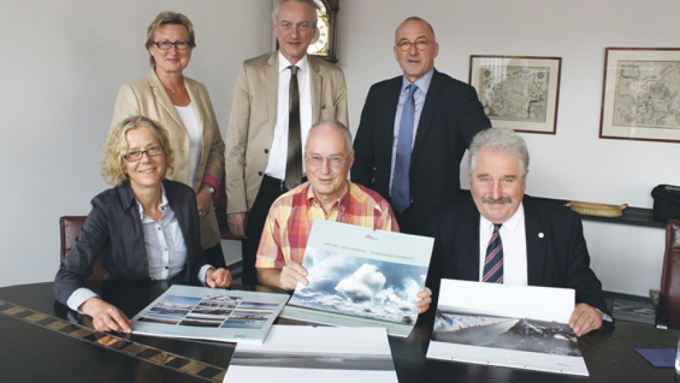 Die Macher des Ostfriesischen Kunstkalenders 2017: Fotograf Michael Schildmann (unten Mitte) zusammen mit Landschaftspräsident Rico Mecklenburg (unten rechts), Brandkassen-Chef Joachim Queck (oben rechts), Landschaftsdirektor Dr. Rolf Bärenfänger, Brandkassen-Pressesprecherin Signe Foetzki (oben links) und Dr. Annette Kanzenbach vom Ostfriesischen Landesmuseum Emden. © Foto: Jürgens