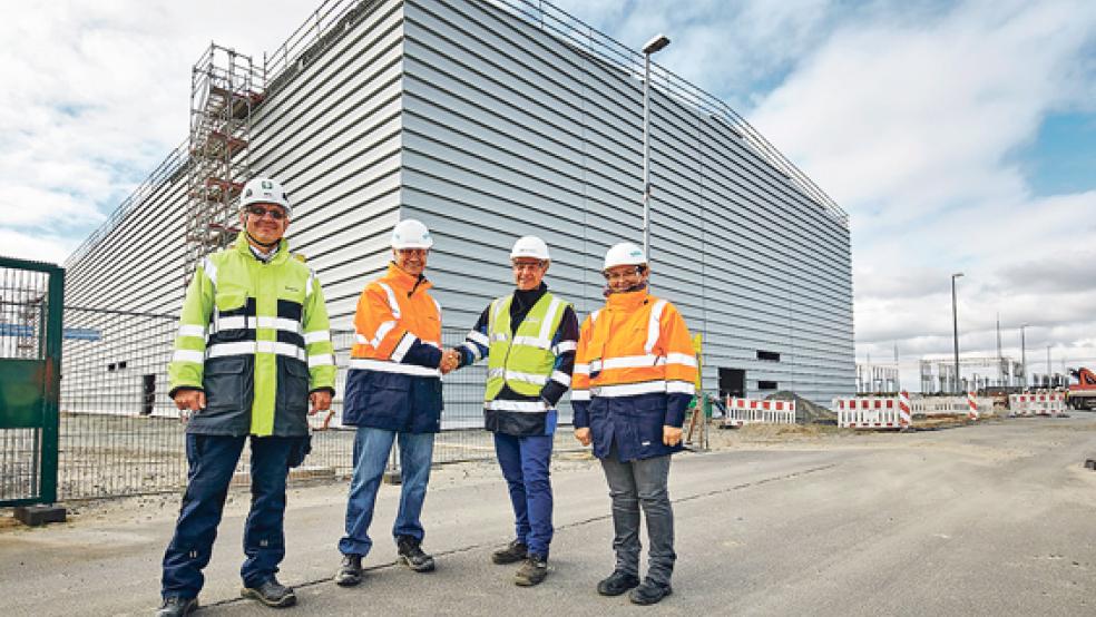 Beim Richtfest: (von links) Jürgen Delzeith (Siemens), Dr. Günther Wanninger (Siemens-Gesamtprojektleiter), Dirk Plischke (TenneT-Projektleiter), Tatjana Basic (technische Projektleitung Siemens) vor der neuen Konverterhalle in Emden. © Foto: TenneT