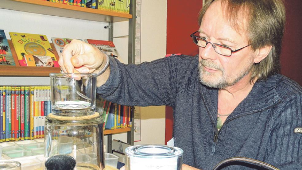 Hendrik Baumann aus Moormerland zaubert Bilder aus Sand in Gläser - eine noch recht unbekannte Kunstform, die in Möhlenwarf viele Blicke auf sich zog. © Fotos: Muising