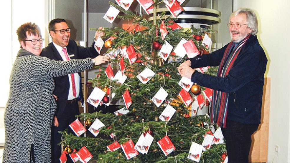 Die Wunschkarten hängten Brigitte Kock-Terveen, Hermann Hanschel und Volker Kraft gestern an den großen Weihnachtsbaum im Sparkassen-Foyer. © Foto: Hoegen