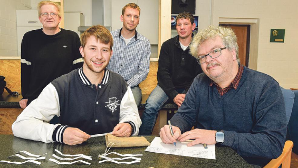 Frank Schulte aus Diele spielte Glücksfee bei der Gruppenauslosung für den Rheiderland-Hallenpokal. Gerald Jungeblut, 1. Vorsitzender des Ausrichters TuS Holthusen (rechts), Rüdiger Herter, Marc Buntjer (2. Vorsitzender) und TuS-Trainer Siegfried August (hinten, von links) hatten bei der Auslosung alles im Blick. © Foto: Bruins