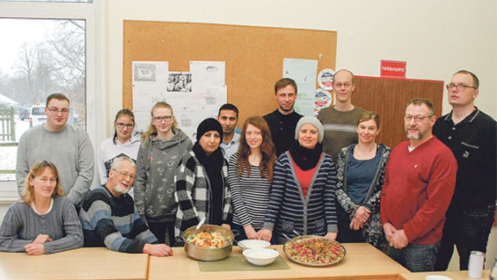 Mitglieder des CVJM mit Franz Kok (sitzend, Zweiter von links) in Weener spenden den Erlös ihrer Baumaktion der örtlichen Initiative »Get together« und wurden zum Mittagessen belohnt mit »Mujadara« (rechts) und »Ghabeli«, zwei arabischen Nationalgerichten aus Afghanistan und Syrien. © Fotos: Kuper