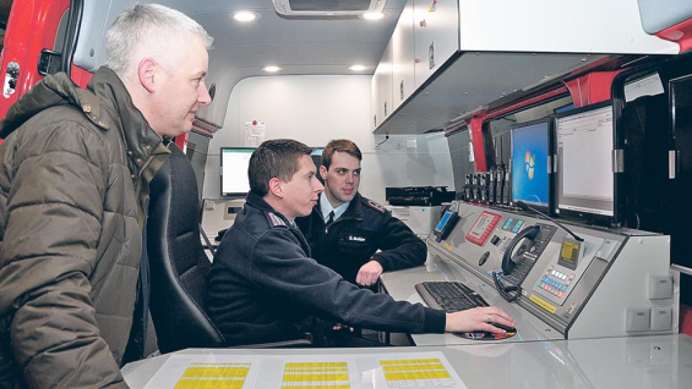 Landrat Matthias Groote (links) ließ sich von Jörg Buß bei der offiziellen Übergabe am Donnerstagabend die Mess- und Kommunikationstechnik im neuen Gerätewagen der Kreisfeuerwehr Leer erläutern. © Foto: Wolters
