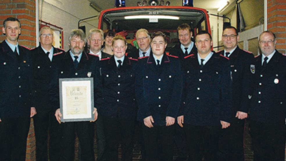 Eckhard Meyer (mit Urkunde) trat vor 25 Jahren in die Feuerwehr ein, während (von links neben ihm) Nike Hassler, Jan Meyer und Dennis Frey jetzt als Anwärter aus der Jugendfeuerwehr in die aktive Abteilung wechselten. Glückwünsche zum Jubiläum und zum Eintritt übermittelten (von links) Ortsbrandmeister Thorsten Duismann und sein Stellvertreter Enno Nagel, Bürgermeister Ludwig Sonnenberg, Silke Krallmann (Fachbereichsleiterin Stadt Weener), Ortsvorsteher Bernhard Siemons, Brandschutzabschnittsleiter Süd Ernst Berends (Kreisfeuerwehr) sowie Stadtbrandmeister Jörg Fisser und sein Stellvertreter Gerhard Kuper. © Fotos: Kuper