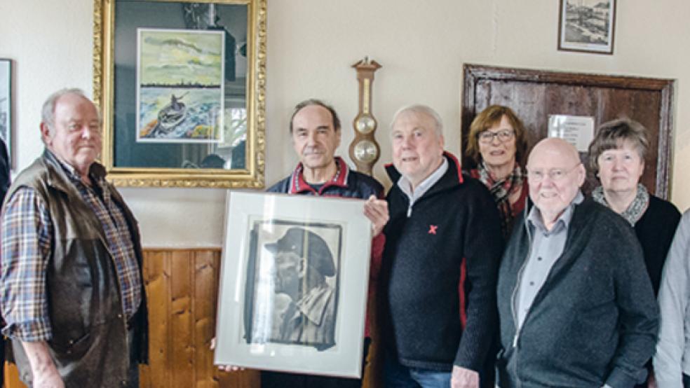 Im Sielhus erinnern zwei Bilder von Kristian Scholz an die Jemgumer Fährzeit und Fährmann »Luitje« Kroon. Der Midlumer Künstler hat sie dem Heimat- und Kulturverein als Dauerleihgabe überlassen. Von links: Wilfried Voß (2. Vorsitzender), Vorsitzender Helmut Kaput, Kristian Scholz, Ernst Scharmacher (Beisitzer), Lore Briese (Schriftwartin), Jan Ulferts (Beisitzer), Klara Kaput (Beisitzerin) und Kassenwart Wilhelm Eenboom.  © Foto: Hanken