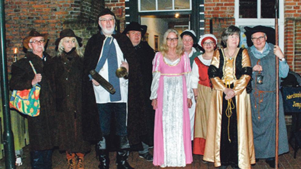 »Nachtwächter« Hillrich Köster (Dritter von links) und seine Helfer Holger Kaput (rechts neben ihm) sowie Willi Eenboom (rechts mit »Schienfatt« und Hellebarde) führten die 45 Gäste durch das nächtliche historische Jemgum. © Fotos: Kuper