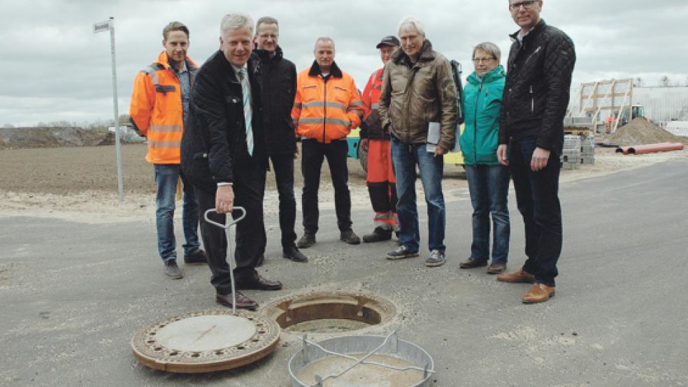 Abnahme der Ersterschließung: Weeners Bürgermeister Ludwig Sonnenberg und Bauamtsleiter Andreas Sinningen (Zweiter und Dritter von links) sowie Bauamtsmitarbeiterin Claudia Nickisch (Zweite von rechts) haben sich gestern Nachmittag gemeinsam mit Rolf Brauner von der Immobiliengesellschaft der Sparkasse Leer-Wittmund (rechts) und Vertretern der Leeraner Straßen- und Tiefbaufirma Huneke unter anderem die Kanalisation im Hessering angeschaut. © Foto: Szyska