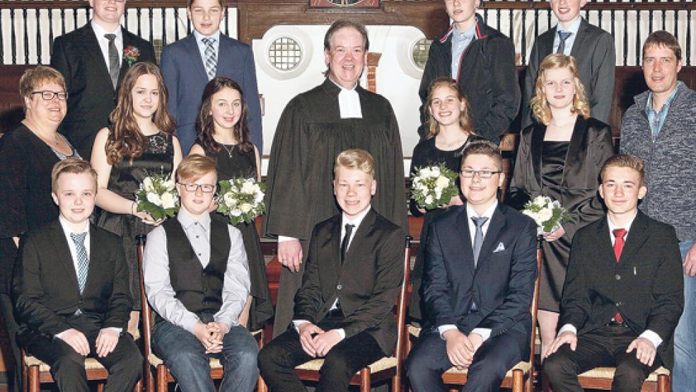 Die Konfirmanden: (vorn sitzend von links): Wilko Fresemann, Kevin Kolkmann, Kevin Müürmann, Renko Dreesmann und Andre Tegeler. Mittlere Reihe: Celina Yzer, Larissa Leemhuis, Julia Goudschaal und Rieke Freerks. Hinten: Maurice Kreutz, Joost Groeneveld, Maris Boekhoff und Hauke Klinkenborg. Vom Kirchenrat wirkten bei der Konfirmation durch Pastor Heiko Rademaker (Mitte) die Kirchenältesten Carola Graalmann (links) und Günther Reck (rechts) mit.  © Foto: B. Lehmann