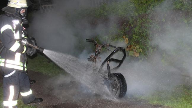 Hecke und Roller in Brand geraten