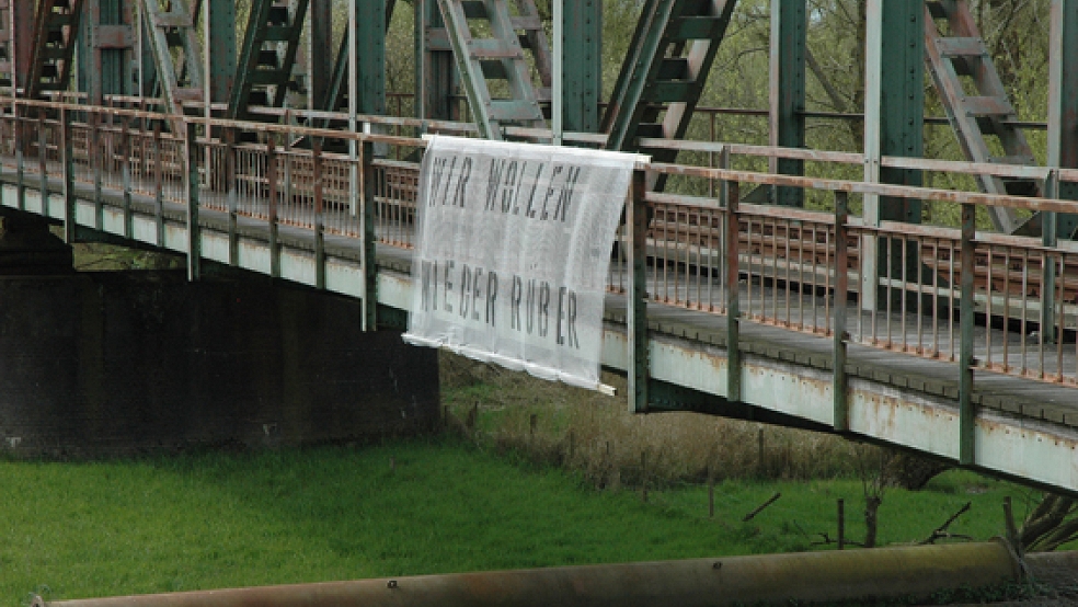 »Wir wollen wieder rüber« steht auf einem Plakat an der durch einen Schiffsunfall zerstörten Friesenbrücke. © Foto: Szyska