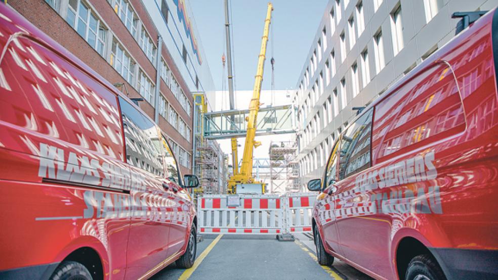 Bauarbeiten auf der Meyer Werft: zwei verglaste Brücken, die das neue Technologie- und Entwicklungszentrum mit dem Verwaltungsgebäude und dem Zentralgebäude der Werft verbinden, werden heute mit zwei Kränen an die jeweiligen Gebäudeteile angebracht und montiert. © Foto: Meyer Werft
