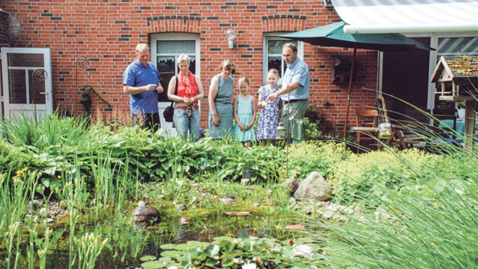 Der naturnahe Garten mit Seerosenteich in Möhlenwarf von Geziena Scholtalbers (auf dem Foto in der Mitte mit Gästen) war einer von insgesamt drei zu besichtigenden Gärten.  © Foto: Kuper