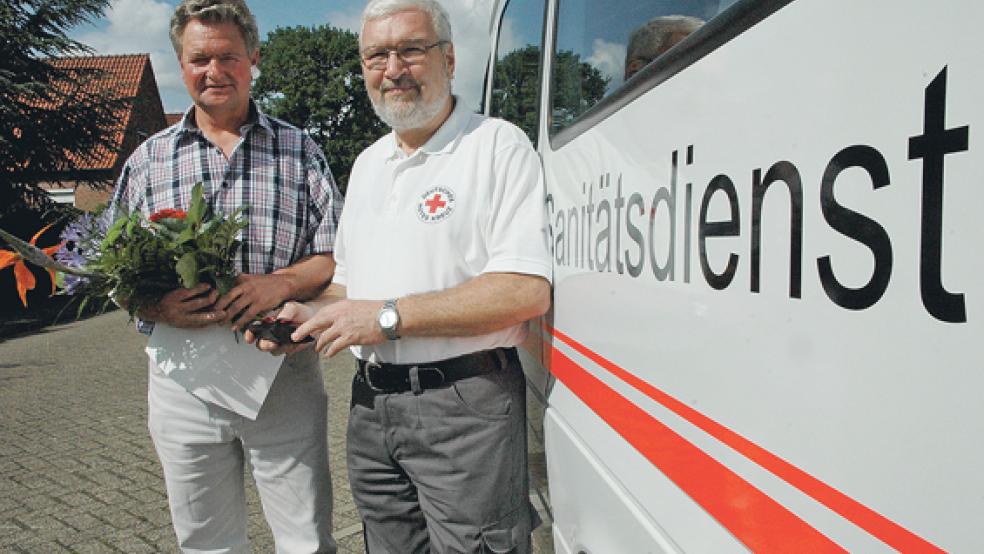 Geerd Freerks (links) wurde von DRK-Bereitschaftsleiter Hermann Pott mit einer goldenen Ehrennadel, einer Urkunde und einem Blumenstrauß geehrt. © Foto: Szyska
