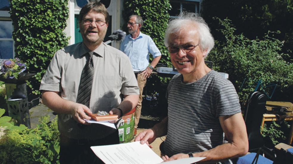 Präses Ard Nap überreicht Pastor Gerke (rechts) die »Emeritierungsurkunde« des Kirchenpräsidenten Dr. Martin Heimbucher, damit ist Gerke offiziell im Ruhestand. © Foto: Kuper