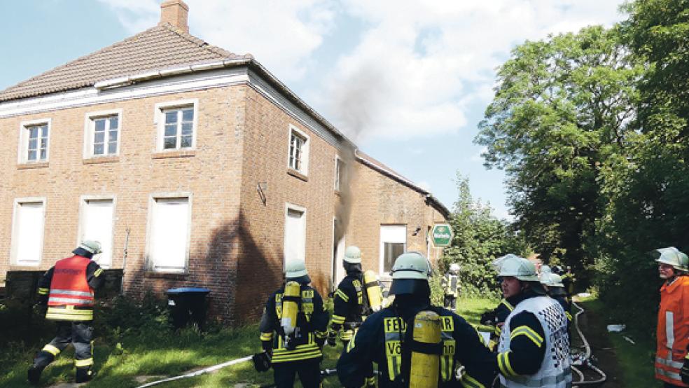 Rauch kommt aus dem Gebäude, ein Einsatztrupp unter Atemschutz geht vor. © Foto: Feuerwehr