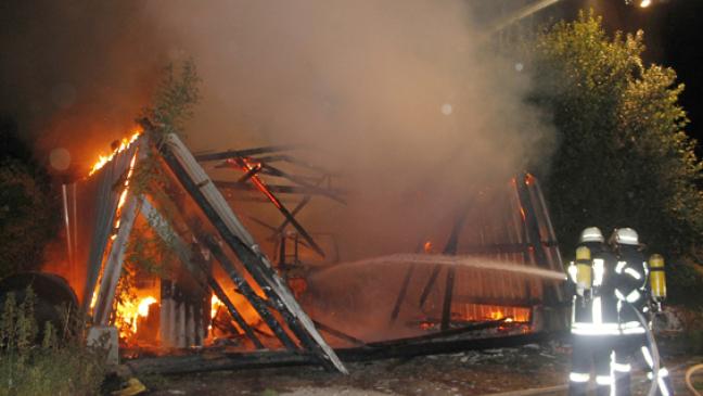 Halle und Rundballen in Flammen