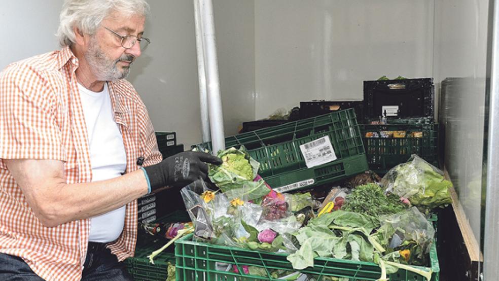 Volker Kraft vom Sozialen Kaufhaus in Weener schaut sich die verdorbenen Lebensmittel an.  © Foto: Boelmann