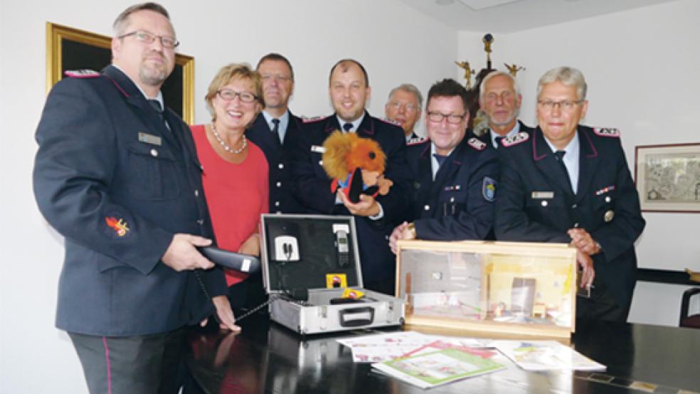 Wollen Kindern die Angst, aber nicht den Respekt vor dem Feuer nehmen: Der Chef des Feuerwehrverbandes Ostfriesland Ernst Hemmen (2. von rechts) an der Seite der Vertreter der Brandkasse Signe Foetzki und Heinz-Herbert Dirks (4. von rechts) sowie die Brandschutzerzieher (von links) Matthias Schmidt (Wittmund), Uwe Weets (Emden) Matthias Rieken (Norden), Bernd Dieter Cordes (Leer) und Friedhelm Saathoff (Aurich). © Foto: Jürgens