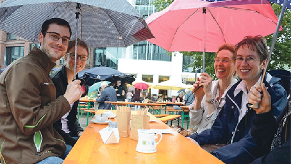 Nicht alle Teetrinker ließen sich durch den strömenden Regen vertreiben. Einige trotzten dem Wetter mit Regenschirmen und guter Laune. © Fotos: Wolters (2), Muising (2)