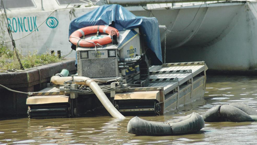 Die Arbeitsmaschine »Truxor DM 5045« saugt den Schlick an und pumpt ihn in die Schleusenkammer. Durch die Öffnung des Schleusentors wird der Schlick aus dem Hafenbecken wieder in die Ems befördert. © Foto: Szyska