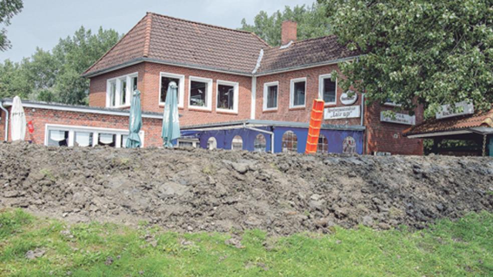 Der Erdwall an der Gaststätte »Luv up« im Jemgumer Hafen war versackt und zunächst provisorisch mit Sandsäcken verstärkt worden. Nun hat der Wassersportverein als Eigentümer das alte Profil wiederhergestellt. In den vergangenen Tagen erfolgten die Nivellierung und die Aussaat von Grassamen. © Foto: Hanken