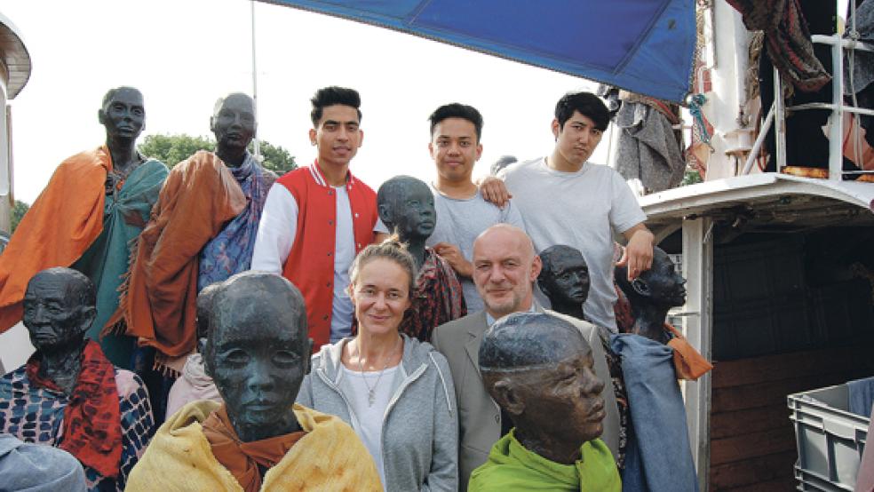 Flüchtlinge inmitten einer Kunstinstallation: 60 Kupferfiguren des dänischen Künstlers Jens Galschiot sind auf der »MS Anton« im Hafen von Weener ausgestellt. Im Bild hinten von links die drei jungen Afghanen Quas, Mahdi und Hassan, die gestern bei drei Vorstellungen von »Pass-Worte - Wie Belal nach Deutschland kam« im Theatercontainer am Hafen auf der Bühne aktiv waren. Vorne Kathrin Hildebrand vom »Lokstoff«-Theater und Schauspieler Sebastian Schäfer. © Foto: Hoegen